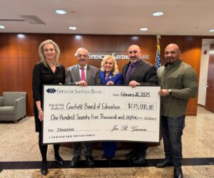 a group of people holding a large check